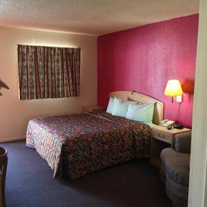 Habitación de hotel con cama y teléfono en Avalon Motel, en Early
