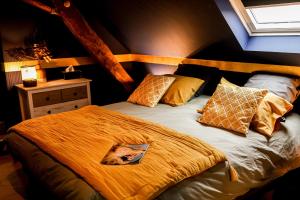 a bedroom with a bed with yellow sheets and pillows at L'Evasion 58 in Nolay