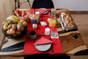 einen Tisch mit einem Teller Essen und einer Schale Obst in der Unterkunft L'Evasion in Nolay