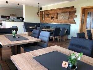 un restaurant avec des tables en bois et des chaises bleues dans l'établissement Landhotel Waldesruh, à Furth im Wald