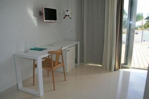 a white desk with a chair and a computer on a wall at Hotel Las Palmas in Carboneras