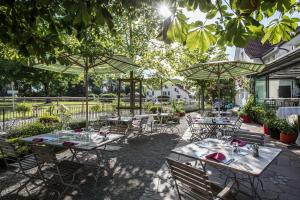 eine Terrasse mit Tischen und Stühlen unter Sonnenschirmen in der Unterkunft Landgasthof Seelust in Egnach