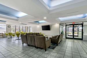 a waiting room with chairs and tables and a tv at Rodeway Inn Wesley Chapel in Wesley Chapel