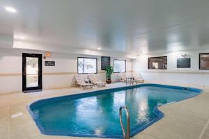 uma grande piscina num quarto com cadeiras em Quality Suites NE Indianapolis Fishers em Fishers