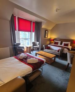 a hotel room with two beds and a couch at Orocco Pier in Queensferry