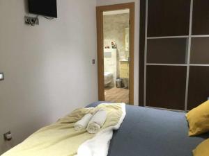 - une chambre avec un lit et des serviettes dans l'établissement Gran piso alto LuzDiseño centrico con garaje, à León