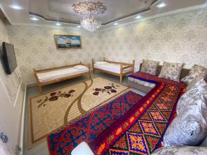 a living room with two beds and a rug at Naryn Guest House in Naryn
