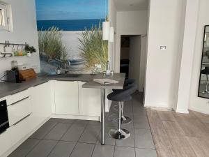 a kitchen with a table and a view of the ocean at Ferienwohnung am Traveufer in Travemünde
