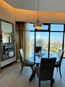 una sala da pranzo con tavolo, sedie e una grande finestra di City View Apartment Nestled in the Heart of NBO a Nairobi