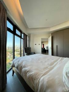 a bedroom with a large bed and a large window at City View Apartment Nestled in the Heart of NBO in Nairobi