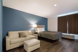 ein Hotelzimmer mit einem Bett und einem Stuhl in der Unterkunft WoodSpring Suites Morrisville - Raleigh Durham Airport in Morrisville