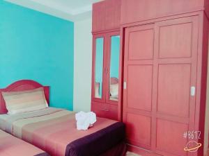 sypialnia z 2 łóżkami i czerwoną szafą w obiekcie Baan Krunah w mieście Krabi