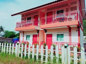 czerwono-biały dom z białym płotem w obiekcie Baan Krunah w mieście Krabi