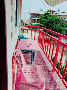 une table et des chaises roses sur un balcon dans l'établissement Baan Krunah, à Krabi