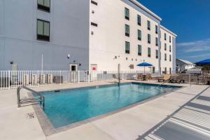 a swimming pool in front of a building at Comfort Inn & Suites Panama City Beach - Pier Park Area in Panama City Beach