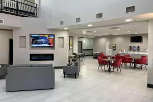a waiting room with tables and chairs and a tv at Comfort Inn & Suites in Lubbock