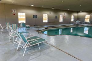 a swimming pool with chairs and a table in front of it at Comfort Inn & Suites in Lubbock