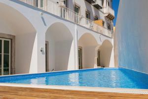 a large swimming pool in a building with white walls at Offline Mood Apartment in Faro