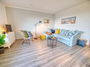 a living room with a blue couch and a table at Meer mit Blick, Dat witte Hus in Rettin