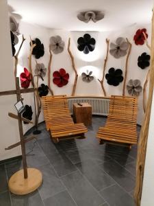 een kamer met banken en bloemen aan de muur bij Fellhorn Ferienwohnungen in Oberstdorf