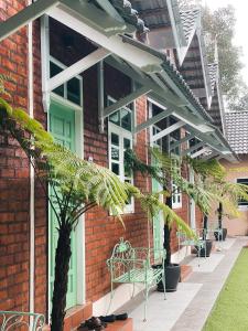 a brick building with a green door and a bench at Gading Chalet in Kuala Terengganu