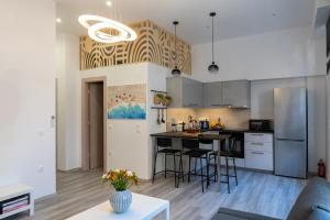 a kitchen and living room with a refrigerator and a table at Central Suites Aegina 2 in Aegina Town
