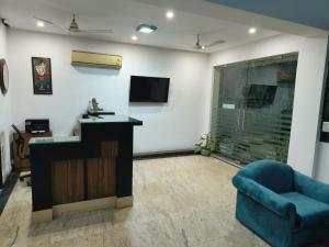a living room with a bar and a blue chair at CABANA REGENCY in Gurgaon