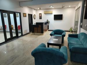 a living room with blue couches and a tv at CABANA REGENCY in Gurgaon