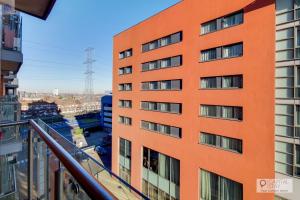 an orange building with a balcony in a city at Deluxe One Bed Apartment by London ExCeL in London