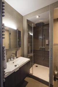 ein Bad mit einer Dusche, einem Waschbecken und einer Duschkabine aus Glas in der Unterkunft Hôtel Restaurant La Montagne De Brancion in Martailly-lès-Brancion