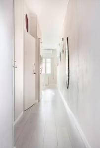 a white hallway with white walls and a mirror at Casa Davide in Sottomarina