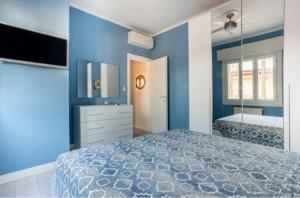 ein blaues Schlafzimmer mit einem Bett und einem Spiegel in der Unterkunft Casa Davide in Sottomarina