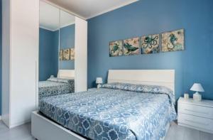 ein blaues Schlafzimmer mit einem Bett und einem Spiegel in der Unterkunft Casa Davide in Sottomarina