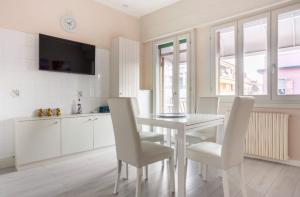 a white kitchen with a white table and chairs at Casa Davide in Sottomarina