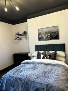 um quarto com uma cama grande e um cobertor azul em Warwick St Studios em Leamington Spa
