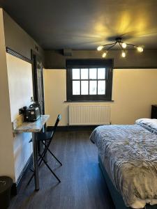 1 dormitorio con cama, mesa y mesa en Warwick St Studios en Leamington Spa