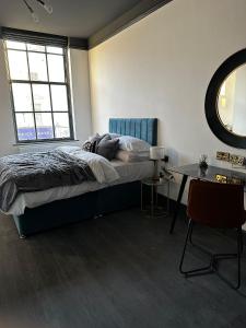 a bedroom with a bed and a window and a table at Warwick St Studios in Leamington Spa