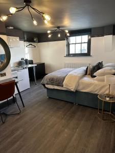 een slaapkamer met een groot bed en een keuken bij Warwick St Studios in Leamington Spa