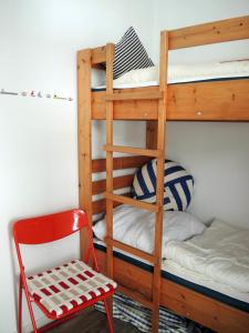ハイリゲンハーフェンにあるIhr Meehrblickの二段ベッド1組(赤い椅子、はしご付)