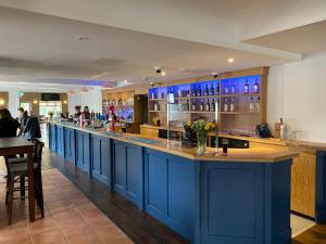 a bar in a restaurant with blue cabinets at Blue Boar Inn in Norwich