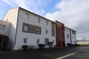 un bâtiment blanc avec un panneau sur son côté dans l'établissement Ace Hotel Issoire, à Issoire