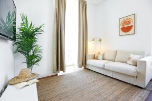 a living room with a white couch and a plant at Ice Cream Call Apartments in Faro