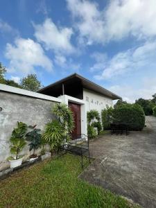 a white building with a red door and some plants at Sand House in Chaweng