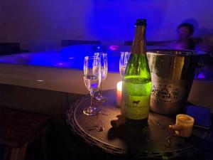 una botella de vino sentada en una mesa con dos copas de vino en Green Mountain Resort, en Scrind-Frăsinet