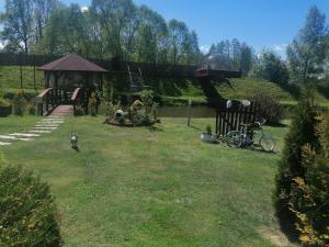 un perro paseando por un patio con parque infantil en siedlisko pod dębami en Romankowo