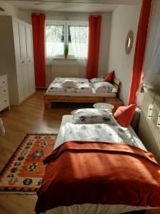 two beds in a bedroom with red curtains at Andrea in Mürzzuschlag