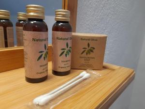 three bottles ofnatural oil sitting on a wooden shelf at Le Ti'nid, idéal pour un séjour à 2 in Wanze