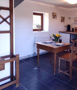 a table and chairs in a room with a kitchen at Le Ti'nid, idéal pour un séjour à 2 in Wanze
