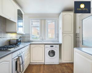 cocina con lavadora y ventana en Fobis Suites Short Lets for 3 Bed Family Group Contractors Dagenham, en Dagenham