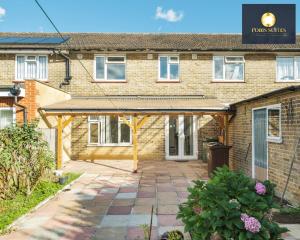 a brick house with a patio in front of it at Fobis Suites Short Lets for 3 Bed Family Group Contractors Dagenham in Dagenham